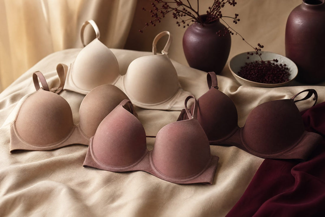 Plusieurs soutiens-gorge couleur peau sans couture disposes sur un tissu creme