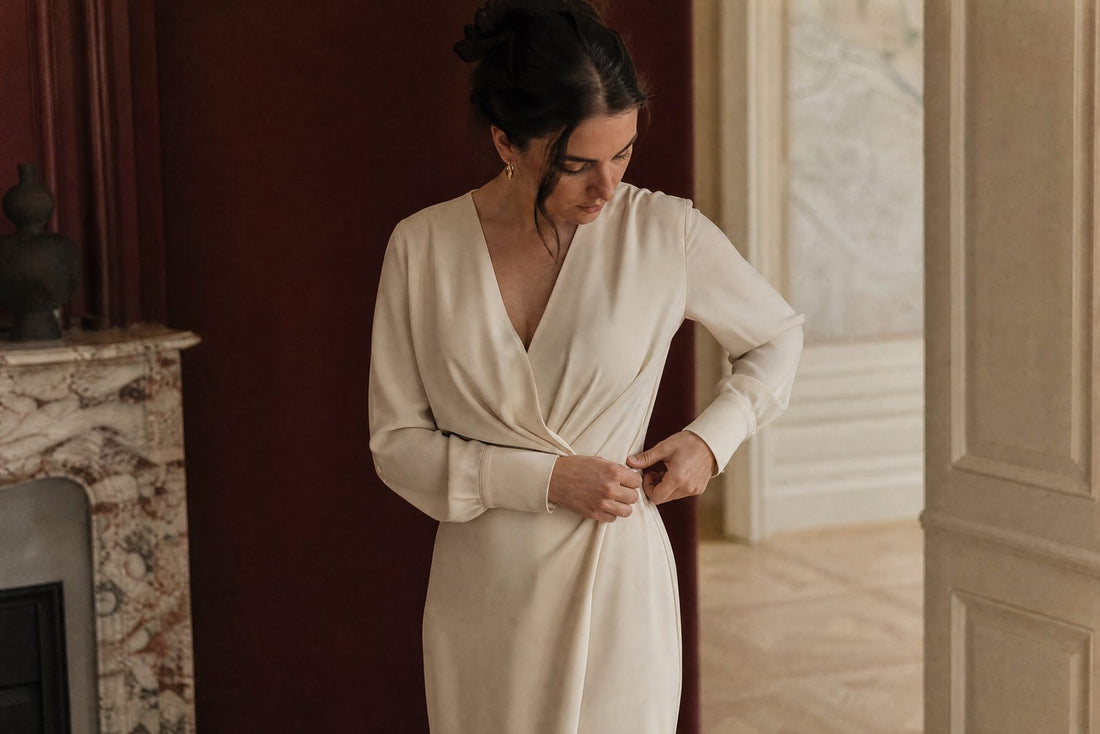 Femme ajustant une robe midi creme a la taille dans une lumiere douce