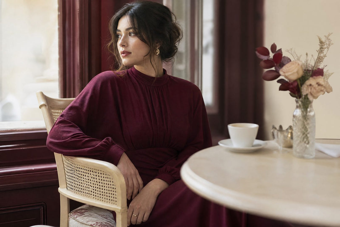 Femme en robe bordeaux chic dans un cafe a la lumiere douce
