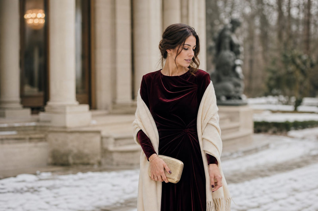 Femme en robe d'invitee en velours bordeaux avec un chale, lumiere hivernale