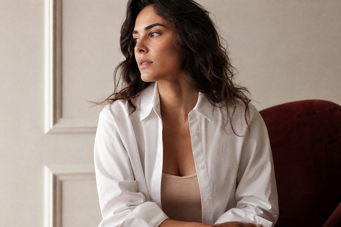 Femme en chemise blanche nette avec un caraco couleur peau, lumiere douce