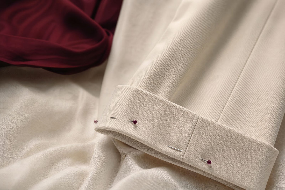 Bas de pantalon avec ourlet net pose sur un tissu creme