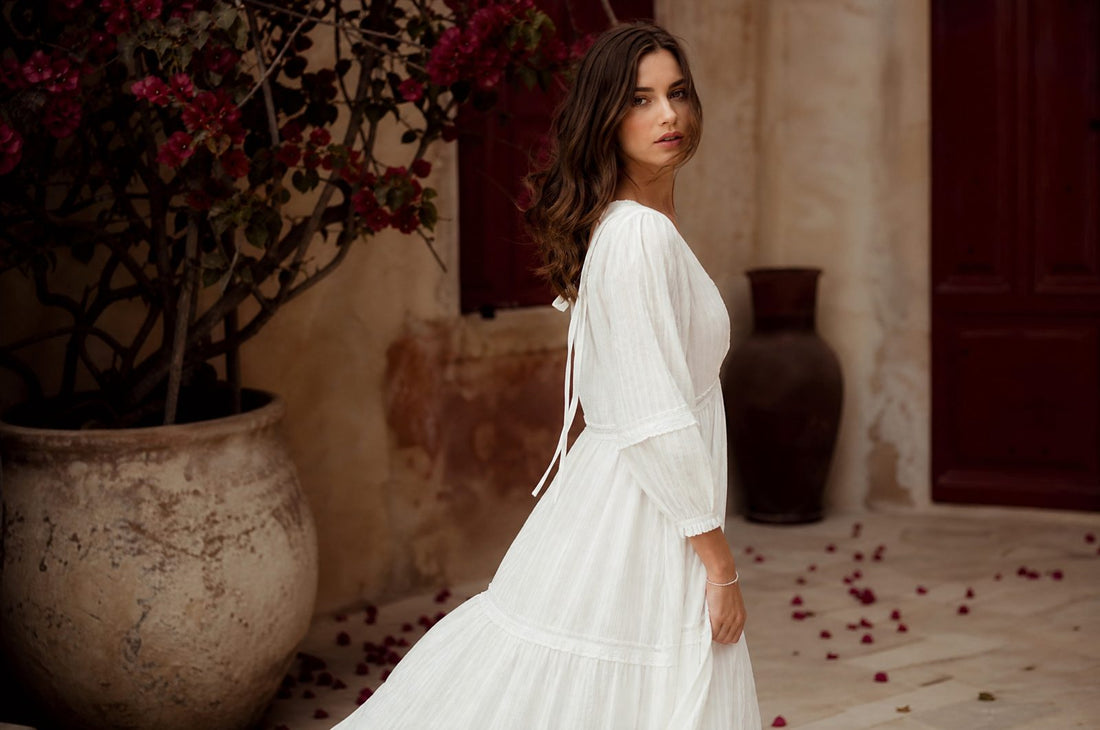 Femme en robe blanche fluide d'ete sous une lumiere chaude